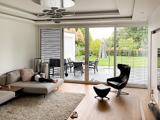 Wohnzimmer mit großen Fenster mit Aussicht auf den Garten